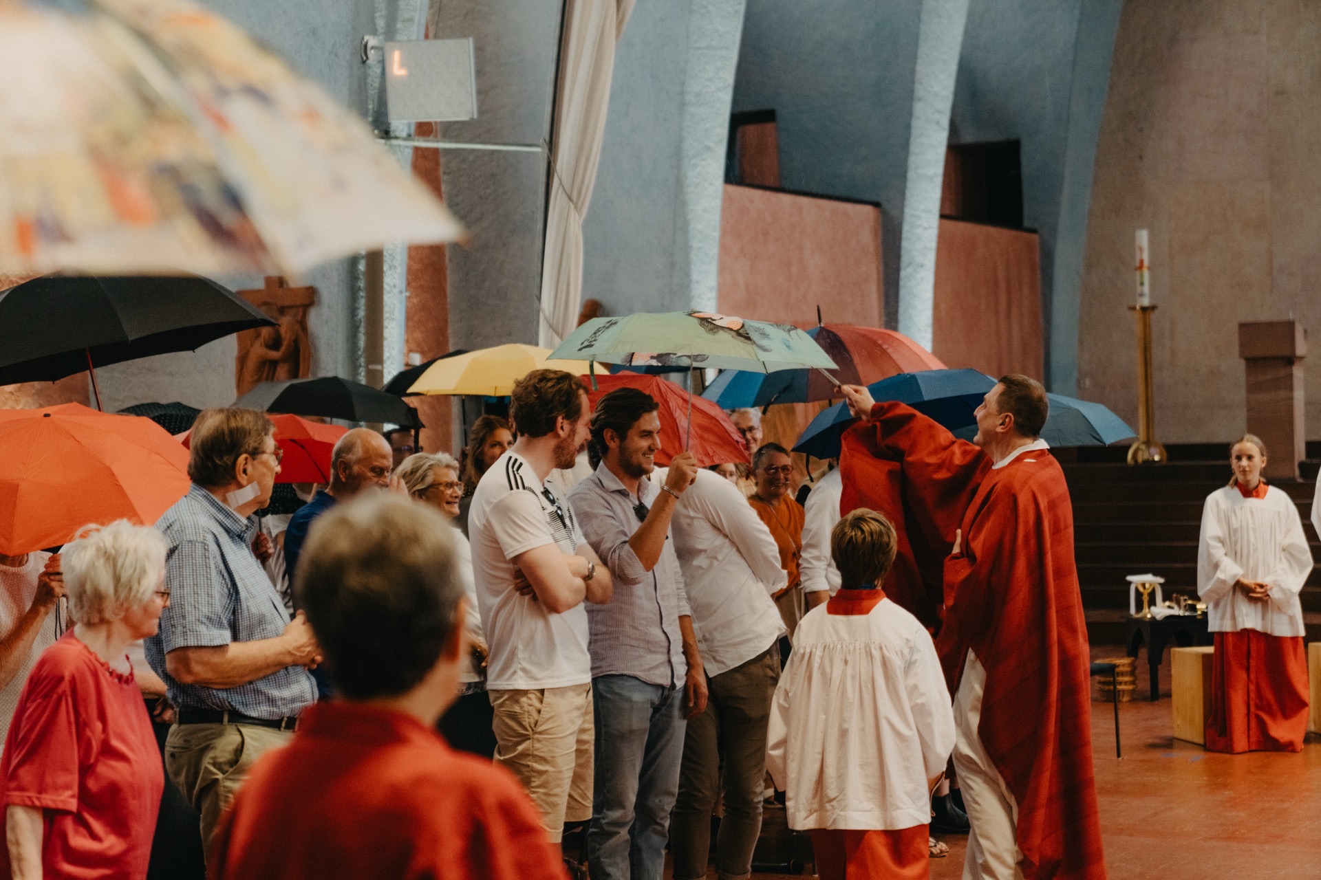 Menschen mit Regenschirmen in einer Kirche