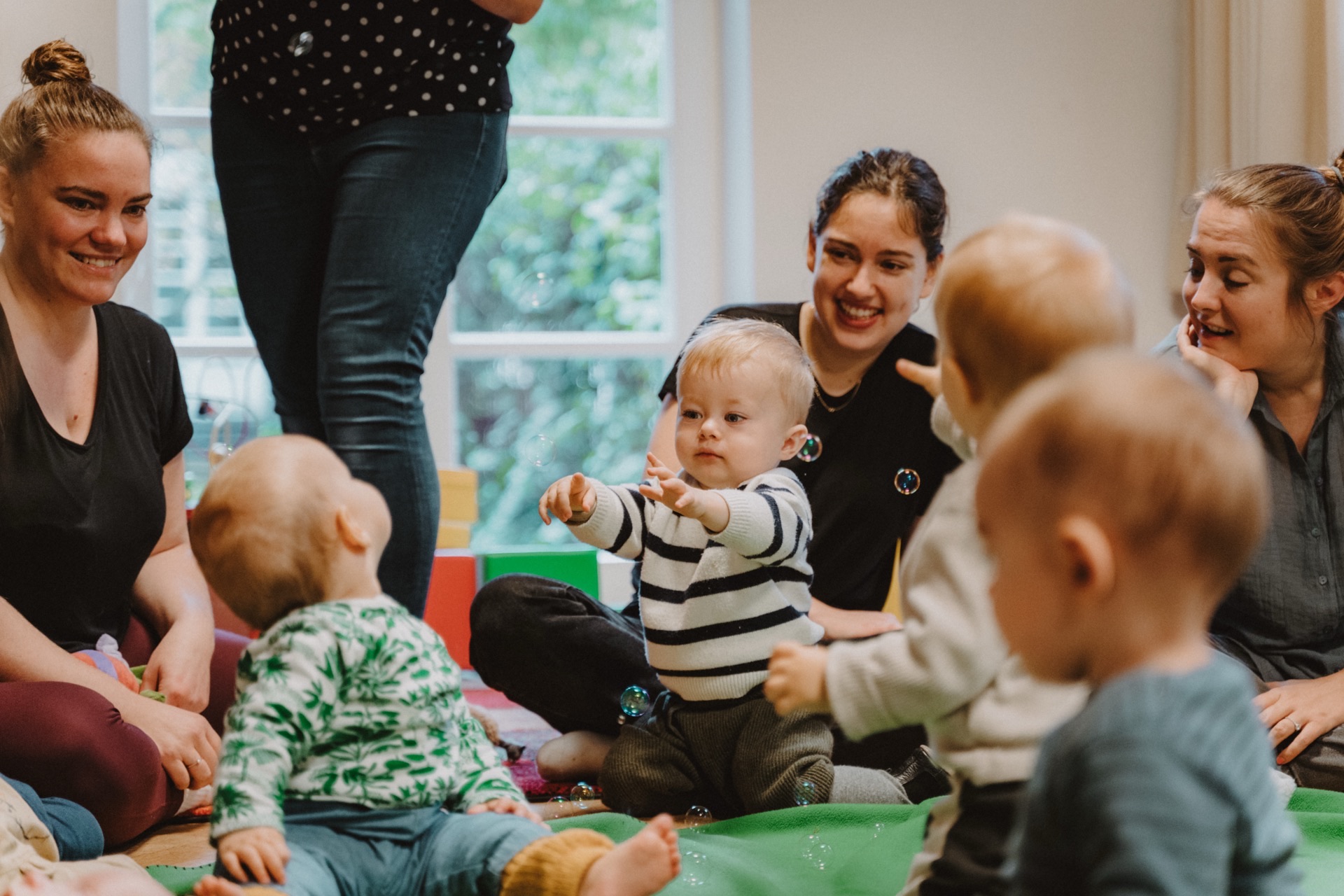Mütter und Babys spielen gemeinsam im Kreis