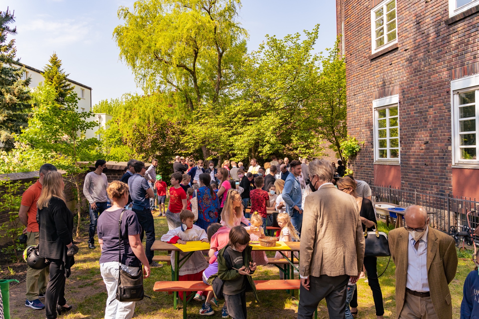Nachbarschaftsfest im grünen Innenhof mit Familien