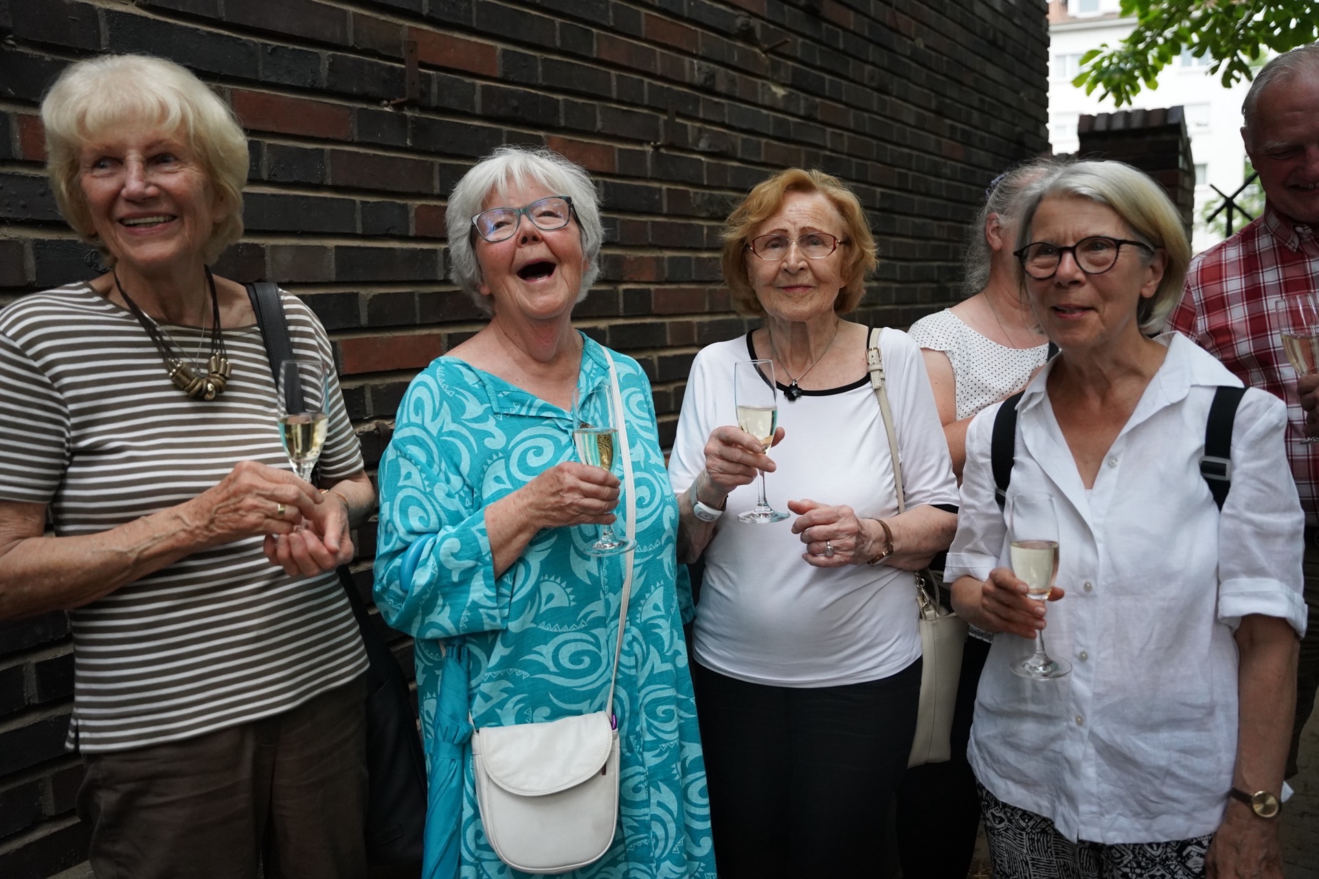 Seniorinnen stoßen mit Sekt im Freien an