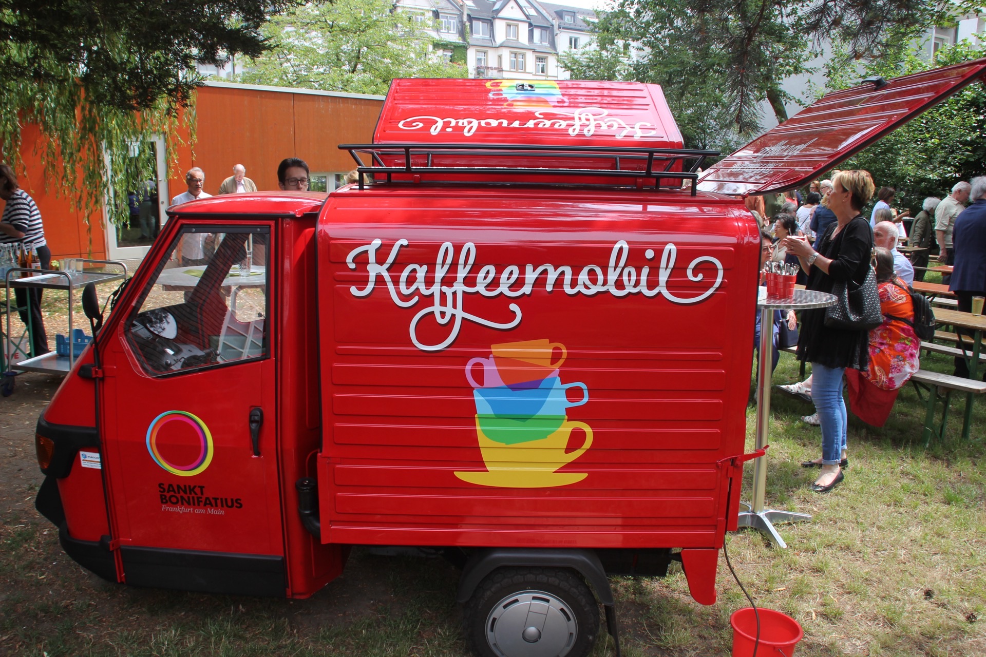 Rotes Kaffeemobil bei Outdoor-Veranstaltung im Park