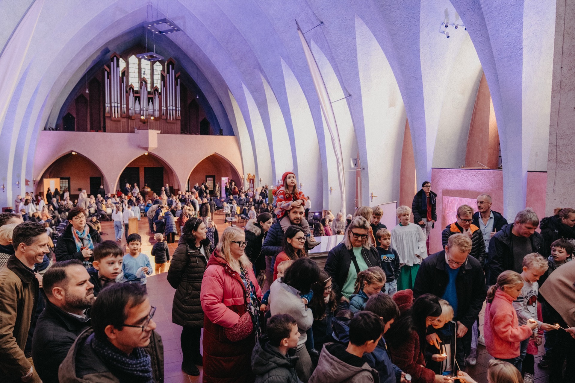 Menschenmenge in Kirche mit Orgel und Kerzen