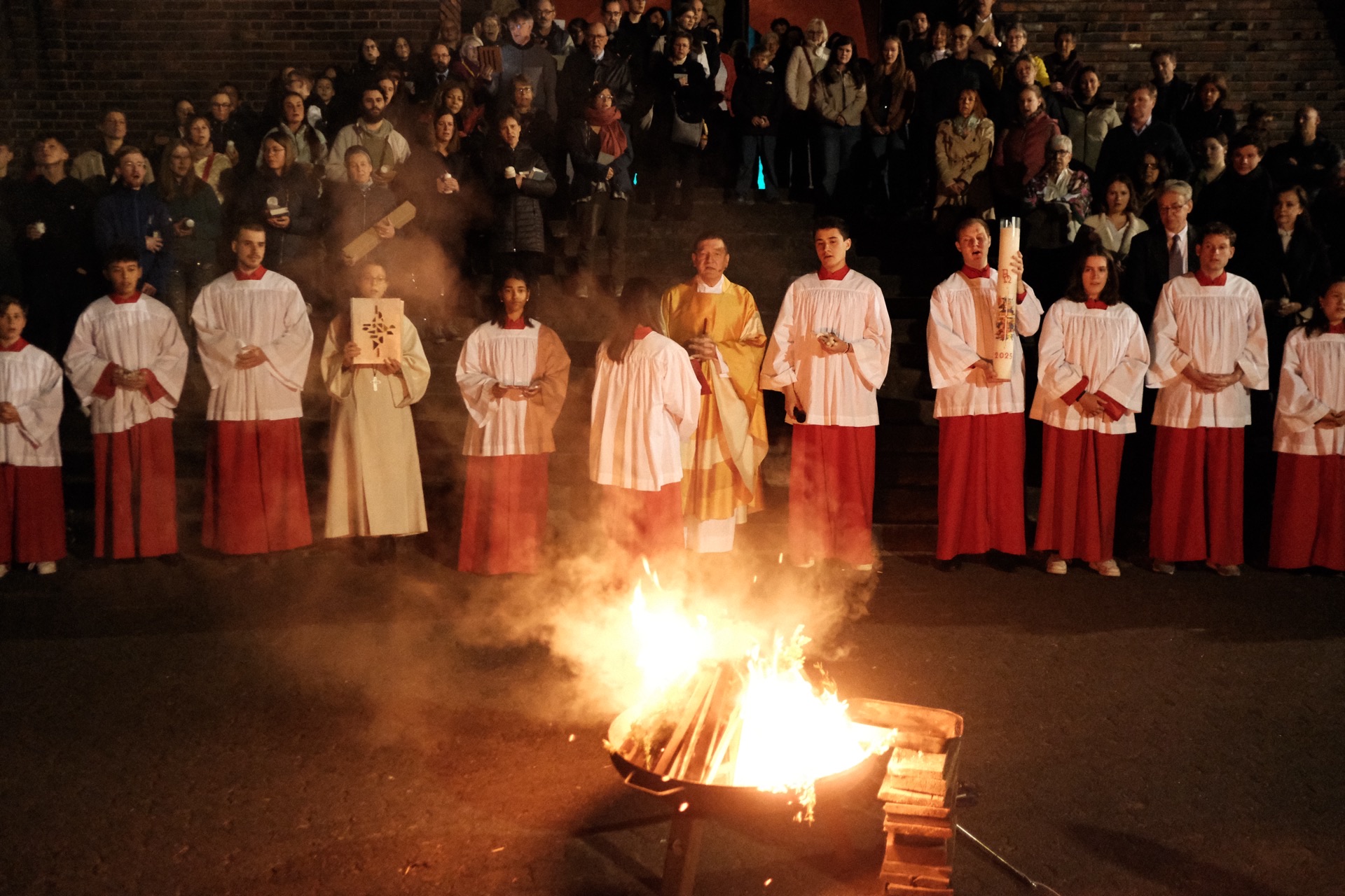 Osterfeuer mit Ministranten und Gemeinde bei Nacht
