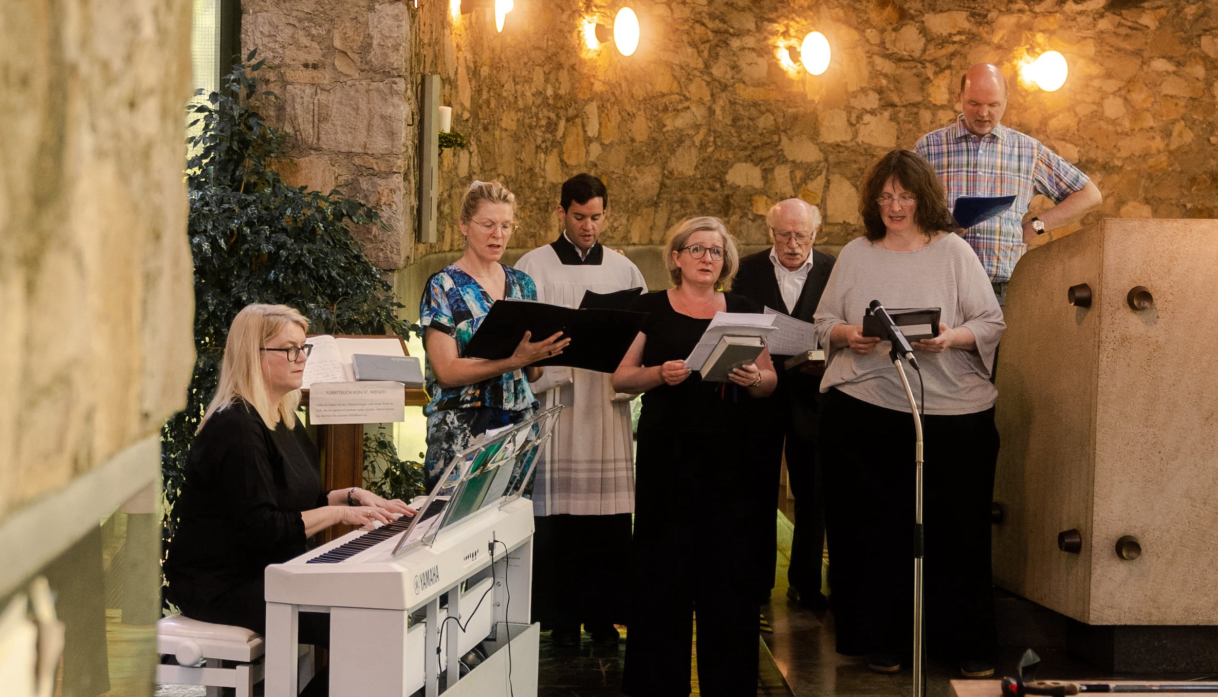 Chor singt in Kirche mit Klavierbegleitung