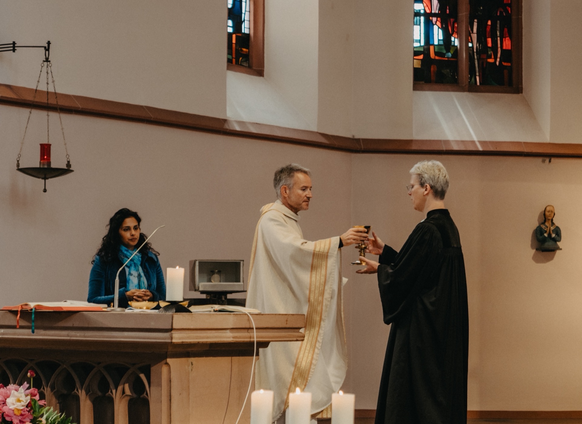 Priester überreicht Kelch während Gottesdienst am Altar