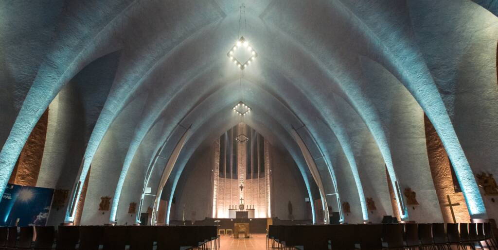 Kircheninterieur mit hohen, gewölbten Decken und Altar.