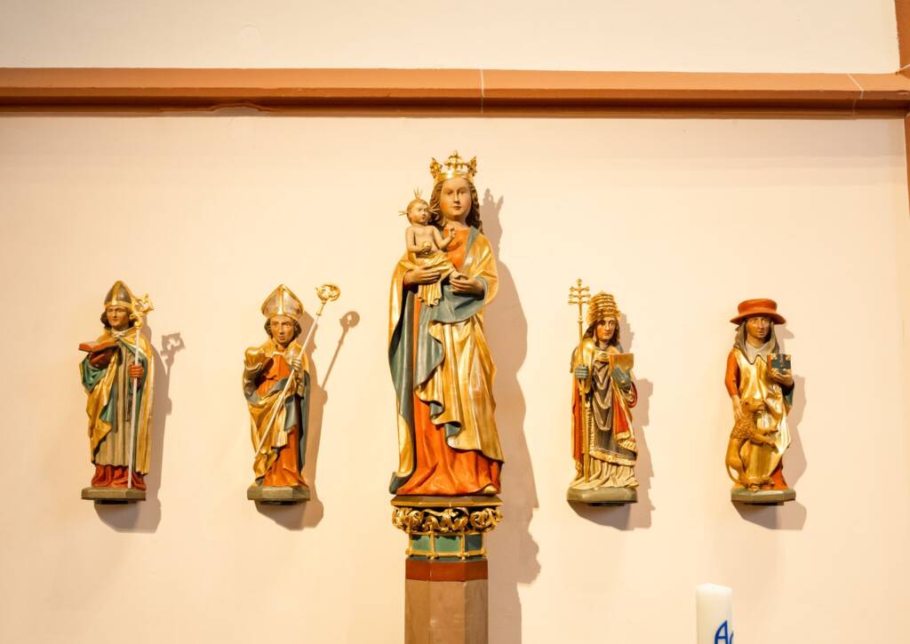 Fünf farbige Heiligenstatuen an einer Wand