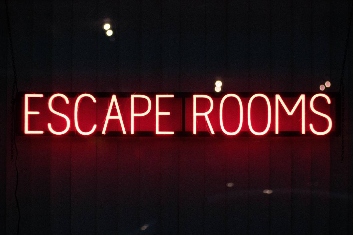 Leuchtendes Schild mit 'Escape Rooms' Schriftzug.