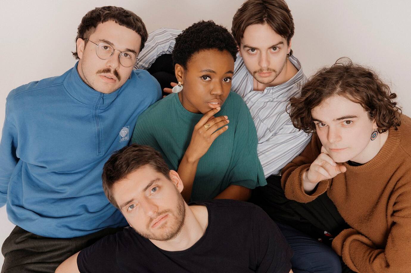 Fünf junge Erwachsene posieren gemeinsam für ein Porträtfoto