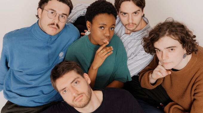 Fünf junge Erwachsene posieren gemeinsam für ein Porträtfoto