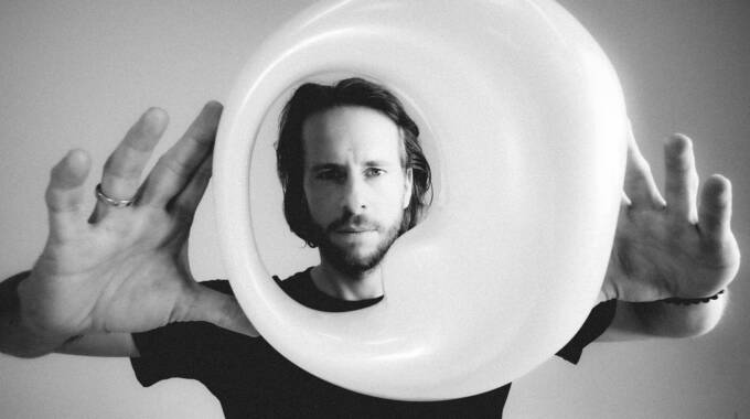 Person hält großes rundes Kunstobjekt vor Gesicht