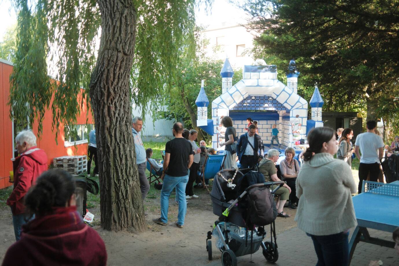 Menschen feiern draußen mit Hüpfburg