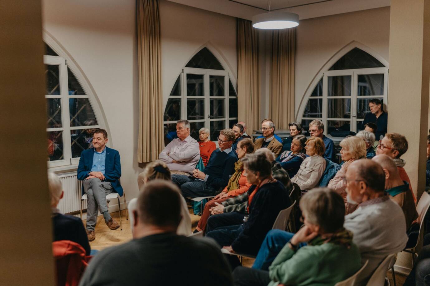 Menschen hören aufmerksam in einem Veranstaltungsraum zu