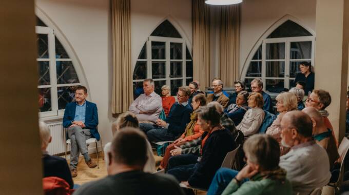 Menschen hören aufmerksam in einem Veranstaltungsraum zu