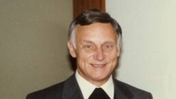 Älterer Mann im Anzug lächelt freundlich