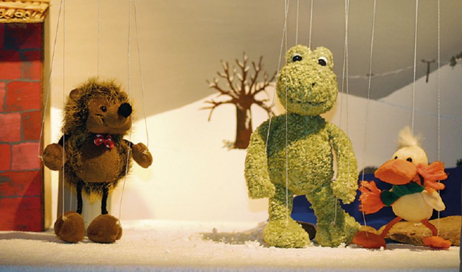 Handpuppen von Igel, Frosch und Ente auf winterlicher Bühne