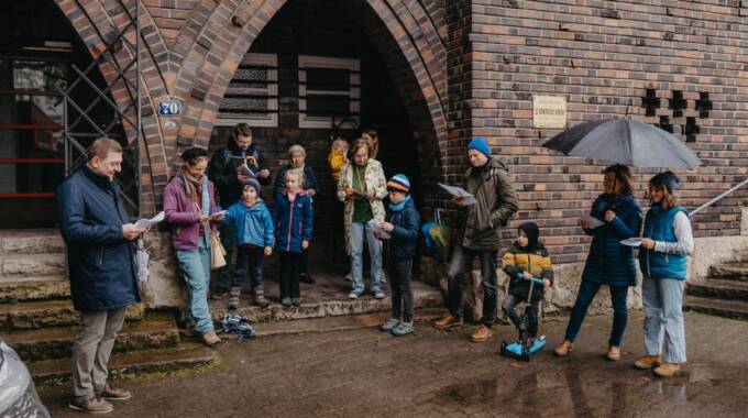 Gruppe singt gemeinsam vor einem Backsteingebäude