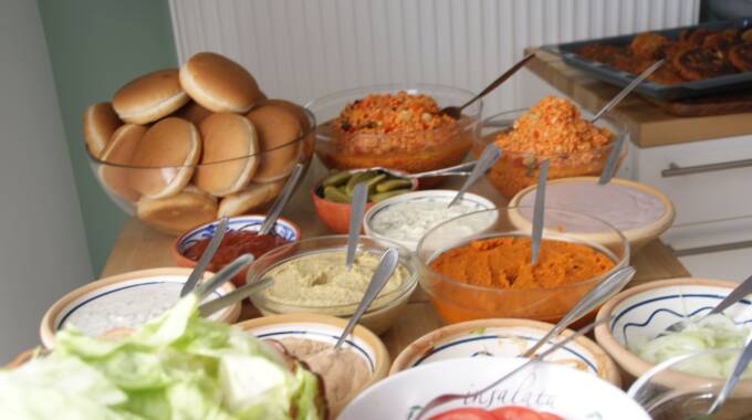 Buffet mit Saucen, Burgerbrötchen und frischem Gemüse