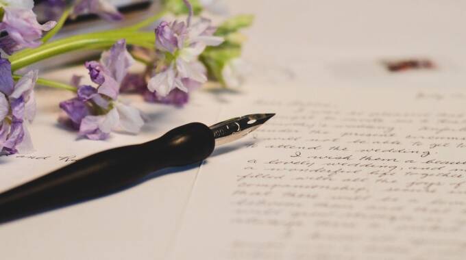 Füllfederhalter und Blumen auf handgeschriebenem Brief