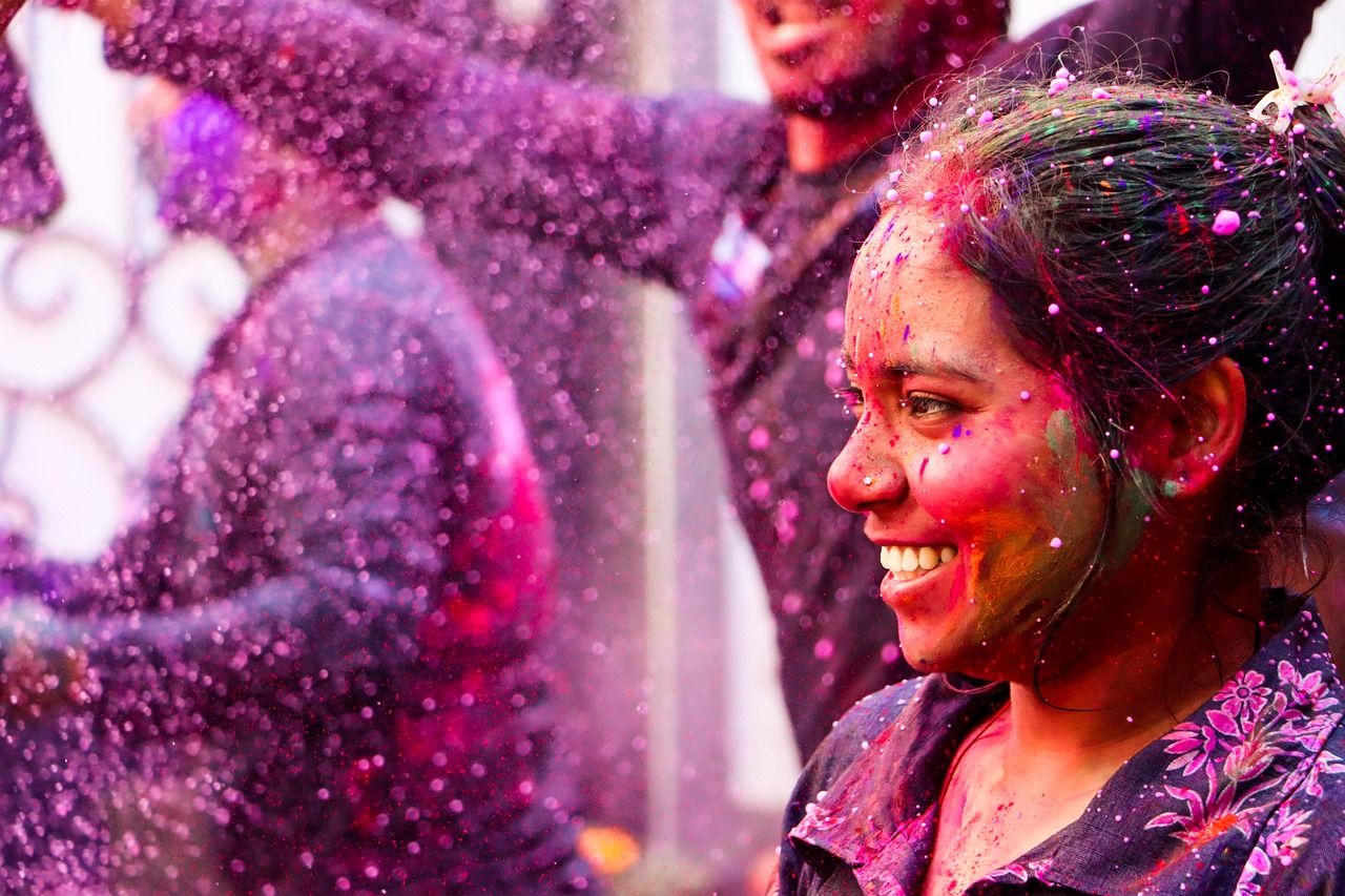 Frau feiert Holi mit buntem Farbpulver