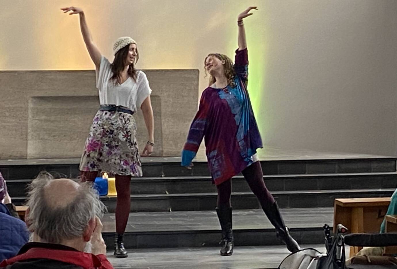 Zwei Frauen tanzen fröhlich auf einer Bühne.