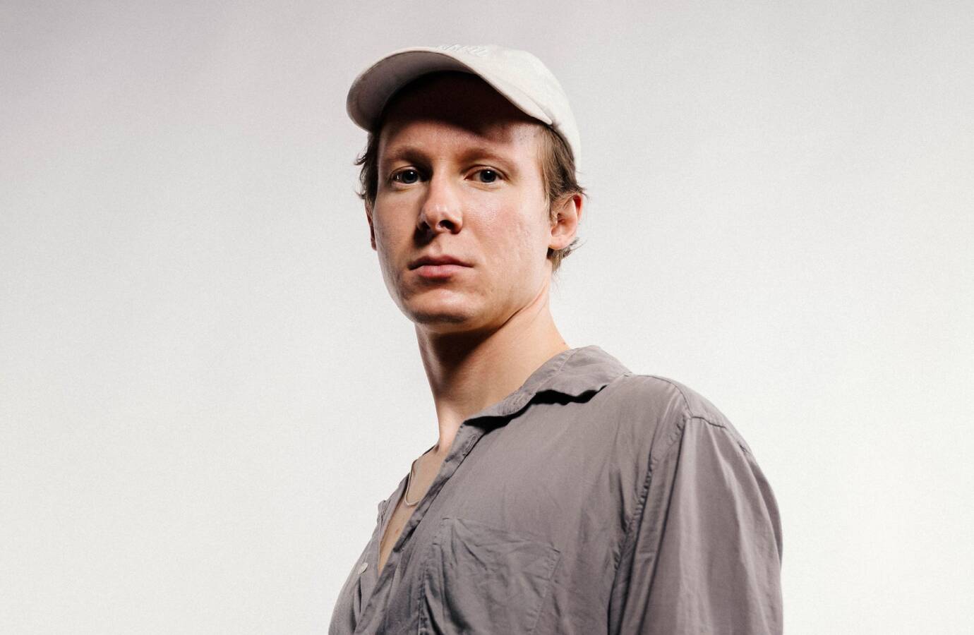 Person mit grauem Hemd und weißer Kappe