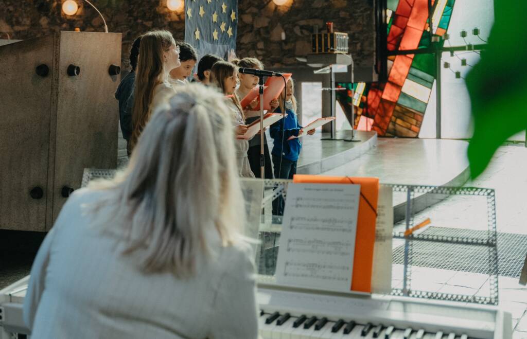 Kinderchor singt in Kirche mit Klavierbegleitung