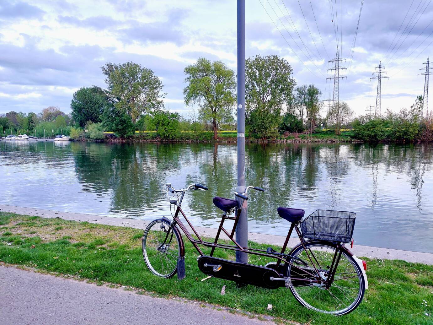 Tandemfahrrad am Flussufer bei bewölktem Himmel