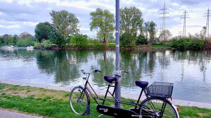 Tandemfahrrad am Flussufer bei bewölktem Himmel