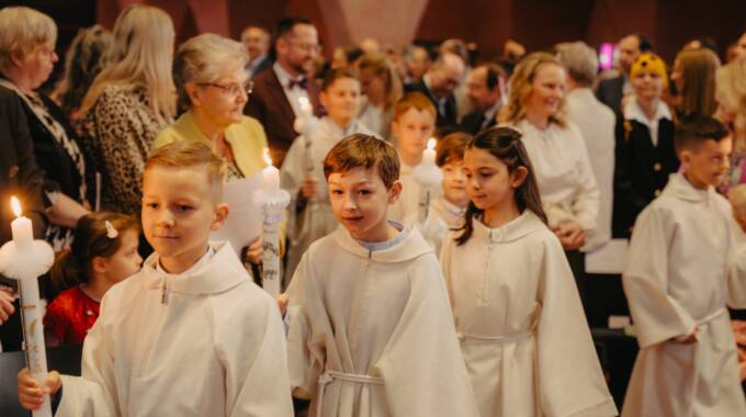 Kinder mit Kerzen bei einer Erstkommunion in Kirche